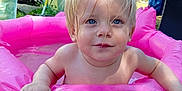 Djayan participe au concours pour gagner de l'argent avec cette photo : child, toddler, baby, inflatable_pool, pink, water, outdoor, summer, garden, greenery, blond_hair, blue_eyes, wet_hair, playing, fun, sunlight, daytime, cute, happy, portrait