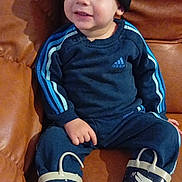 Djayan participe au concours pour gagner de l'argent avec cette photo : toddler, child, beanie, hat, adidas, tracksuit, rain_boots, owl, blue, leather_couch, indoor, sitting, cute, smiling, casual_clothing, footwear, portrait, young_child, cozy, happy