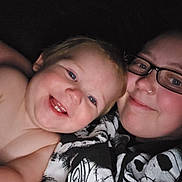 Edward is registered to the contest to win money with this photo: baby, adult, glasses, smile, happy, cuddle, portrait, face, closeup, indoors, cozy, person, young_child, casual_clothing, hoodie, glasses_wearer, skin, blue_eyes, joy, affection