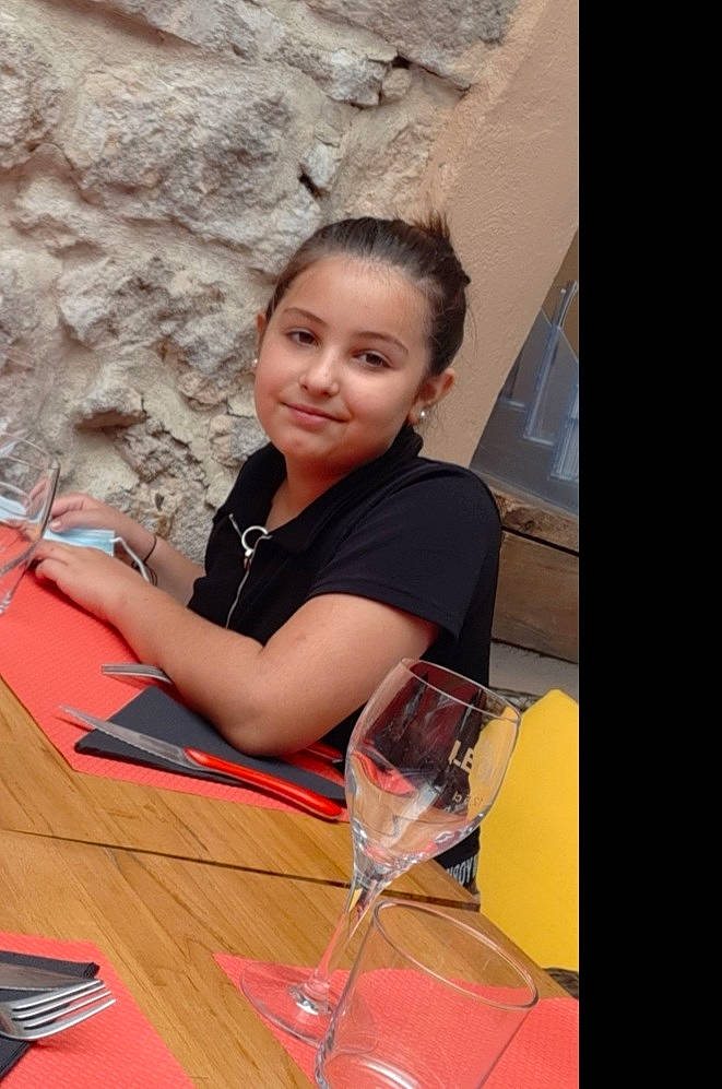 Lupita participe au concours pour gagner de l'argent avec cette photo : chair, child, fashion_design, flash_photography, flooring, fun, happy, human_leg, joy, leisure, person, plate, recreation, room, sitting, smile, table, tableware, thigh, vacation