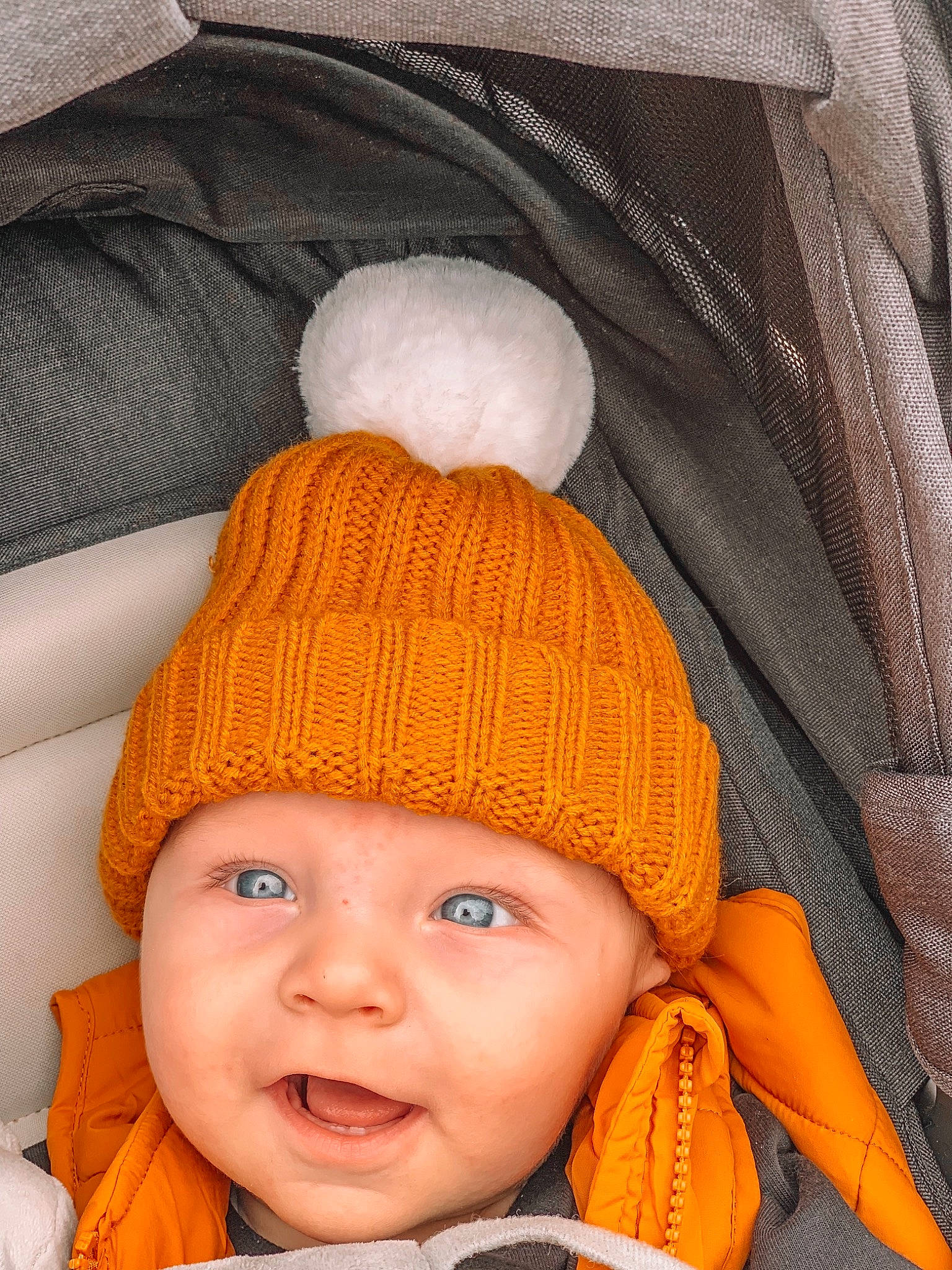 Storm is registered to the contest to win money with this photo: baby, beanie, bonnet, cap, cheek, child, clothing, crochet, ear, eye, hat, headgear, headwear, knit_cap, knitting, orange, person, toddler, wool, woolen