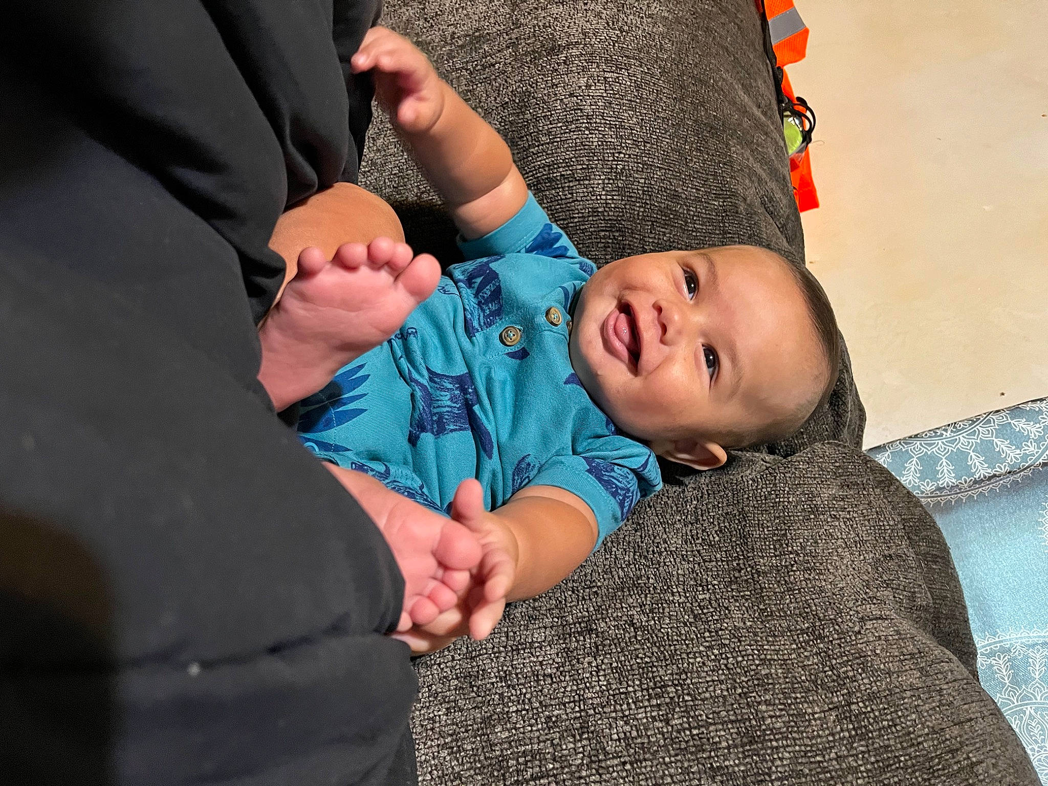 Mateo is registered to the contest to win money with this photo: baby, baby_toddler_clothing, cheek, child, comfort, electric_blue, eye, finger, fun, gesture, grass, happy, head, joy, pattern, person, sitting, sleeve, smile, thumb