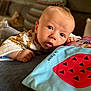 Mayson participe au concours pour gagner de l'argent avec cette photo : baby, infant, face, eyes, cute, lying_down, clothing, animal_print, pillow, toy, living_room, couch, blurred_background, child, skin, head, hand, expression, soft_surface, indoors