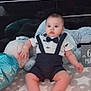 baby, infant, birthday_cake, candle, clothing, bow_tie, suspenders, blanket, star_pattern, plush_toy, floor, home_interior, television, decor, plate, celebration, child, sitting, cute, indoor