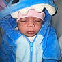 Elyn a rejoint le concours — aidez-le/la à gagner de superbes lots ! baby, sleeping, blue_onesie, hood, child, cute, infant, soft, warm, cozy, pink_hat, closeup, face, hands, zipper, plush, adorable, costume, indoor, resting