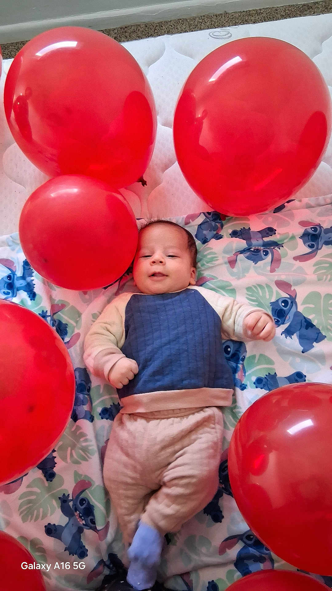 Massine joined the competition — help win amazing prizes! baby, balloon, blanket, blue_clothing, carpet, child, cute, face, floor, infant, indoors, laying_down, light, mattress, one_person, pale_skin, red_balloon, socks, smiling, toddler