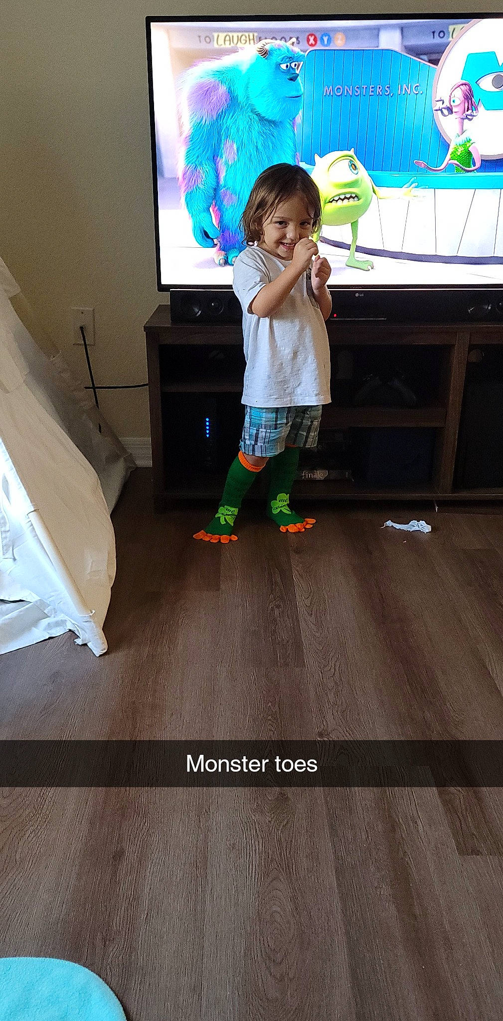 Cayson is registered to the contest to win money with this photo: child, drawer, floor, flooring, fun, hardwood, human_leg, joy, laminate_flooring, leg, leisure, person, play, sportswear, t_shirt, table, television, television_set, thigh, toddler