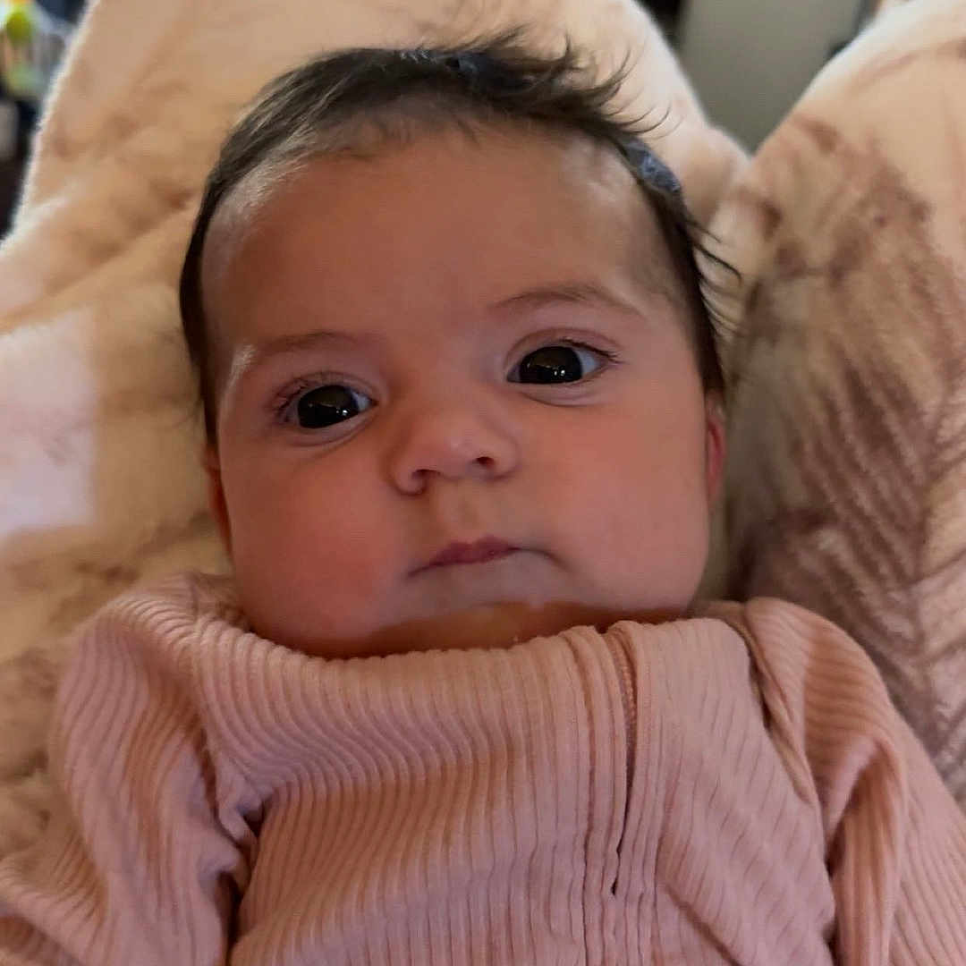 Maebre is registered to the contest to win money with this photo: baby, blanket, child, closeup, clothing, cozy, cute, face, gaze, indoors, infant, newborn, person, pink, portrait, ribbed_fabric, soft, toddler, warm, young