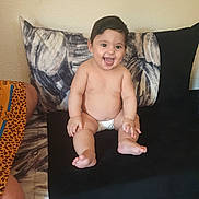 Céline Rajwa a rejoint le concours — aidez-le/la à gagner de superbes lots ! baby, diaper, smiling, sitting, couch, pillow, indoor, child, happy, person, barefoot, cute, infant, plush, home, wall, furniture, skin, expression, young