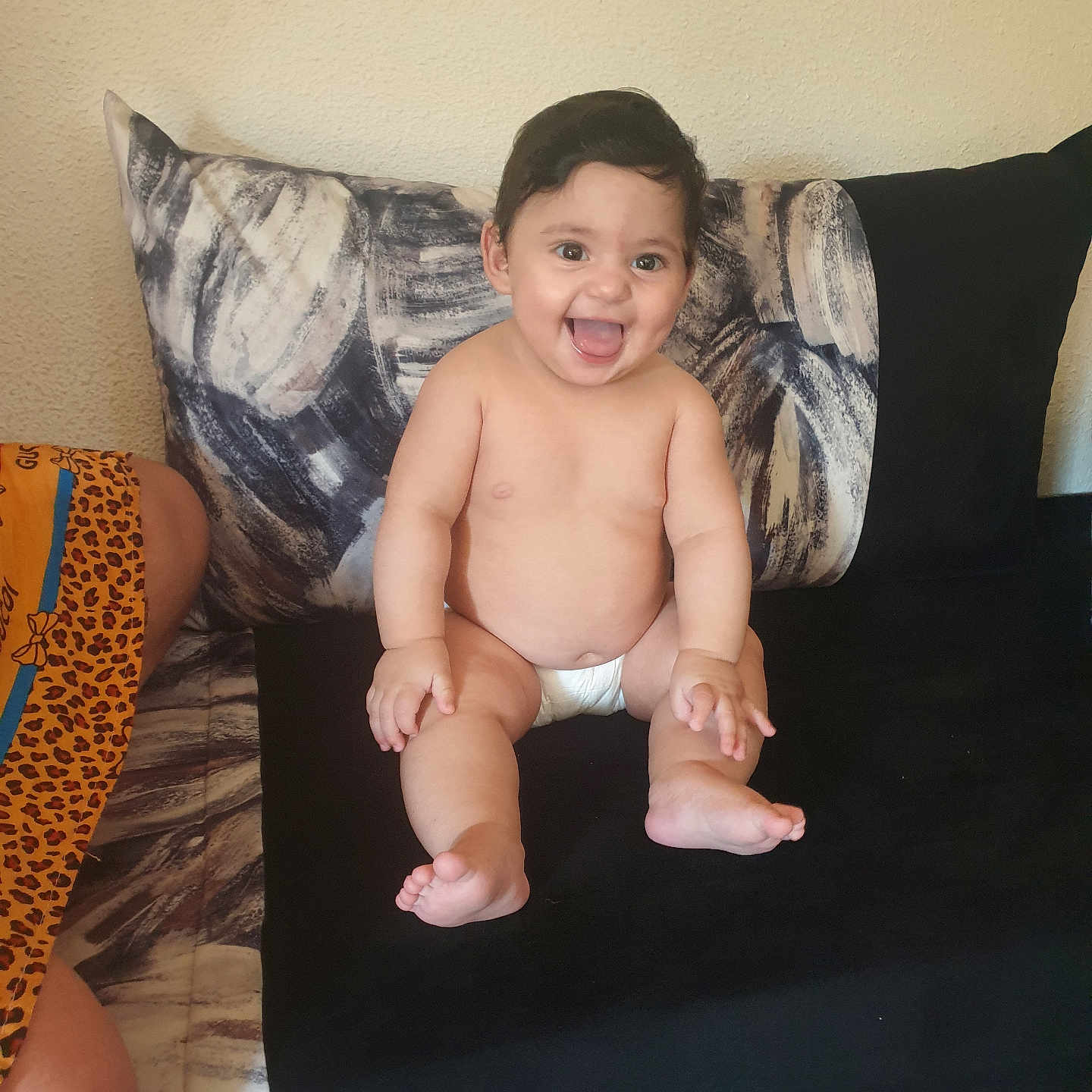 Céline Rajwa a rejoint le concours — aidez-le/la à gagner de superbes lots ! baby, barefoot, child, couch, cute, diaper, expression, furniture, happy, home, indoor, infant, person, pillow, plush, sitting, skin, smiling, wall, young