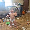 Emmett is registered to the contest to win money with this photo: chair, child, clutter, curly_hair, daylight, diaper, door, face, furniture, household_objects, indoors, living_room, portrait, shirtless, smiling, standing, toddler, toy, window, wooden_floor