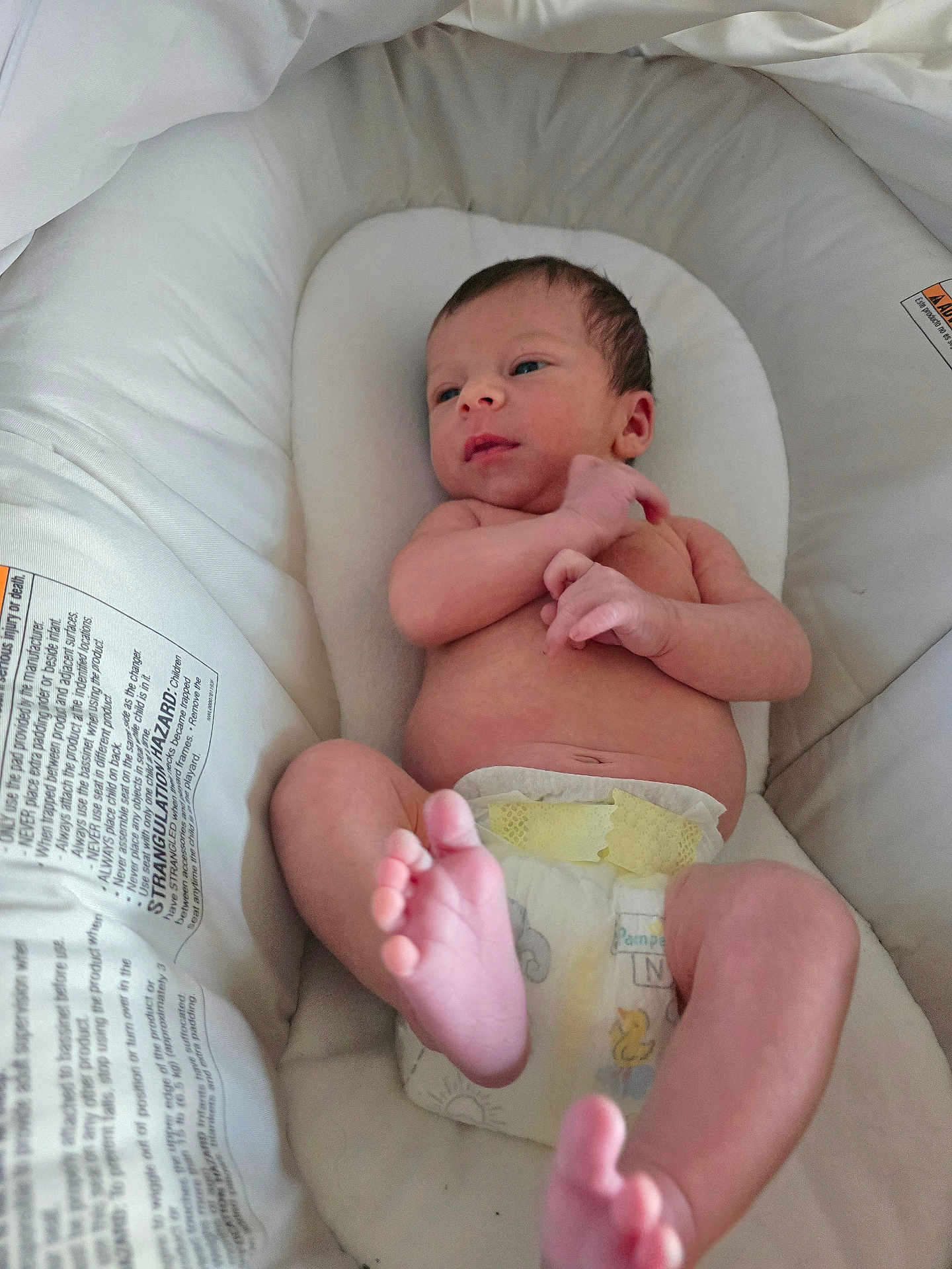 Emmett is registered to the contest to win money with this photo: baby, newborn, diaper, infant, bassinet, white, sleeping_bed, feet, hand, skin, cute, resting, child, person, indoors, soft, comfort, closeup, portrait, relaxing