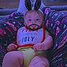 Emmett is registered to the contest to win money with this photo: baby, child, bib, bunny_ears, beard, digital_filter, legs, pajamas, foot, face, indoor, person, sitting, cute, playful, funny, sparkles, yellow_clothing, relaxing, home