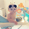 baby, child, cute, diaper, dog_ears, dog_nose, face_filter, filter, floor, furniture, indoor, kitchen, light_flare, person, playful, smiling, standing, toy, walker, window
