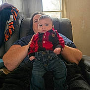 Emmett is registered to the contest to win money with this photo: adult, baby, blanket, casual, chair, child, clothing, curtains, face, hand, home, indoor, jeans, person, plaid, portrait, relaxed, shirt, sitting, window