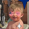 Emmett is registered to the contest to win money with this photo: american_flag, baby, blanket, cardboard_box, child, clutter, cute, expression, face, funny, head, indoor, infant, person, purple, seated, skin, smile, star_graphic, sunglasses