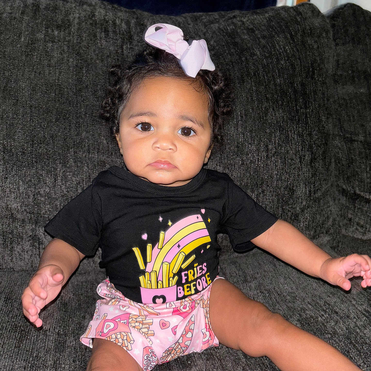 Naomi is registered to the contest to win money with this photo: architecture, baby, bodypart, building, clothing, couch, cushion, face, finger, furniture, hand, head, homedecor, indoors, person, photography, portrait, shorts, sitting, t_shirt
