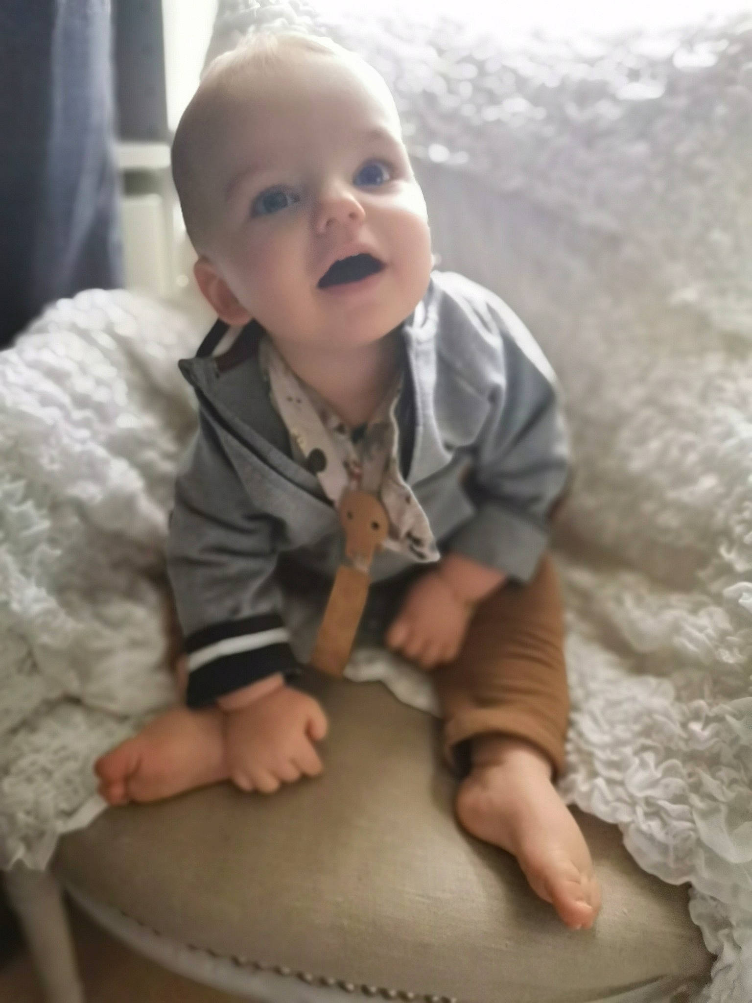 Liam participe au concours pour gagner de l'argent avec cette photo : arm, baby, baby_toddler_clothing, cheek, chin, comfort, eyebrow, face, finger, floor, flooring, hand, happy, human_body, iris, nose, person, skin, sleeve, smile