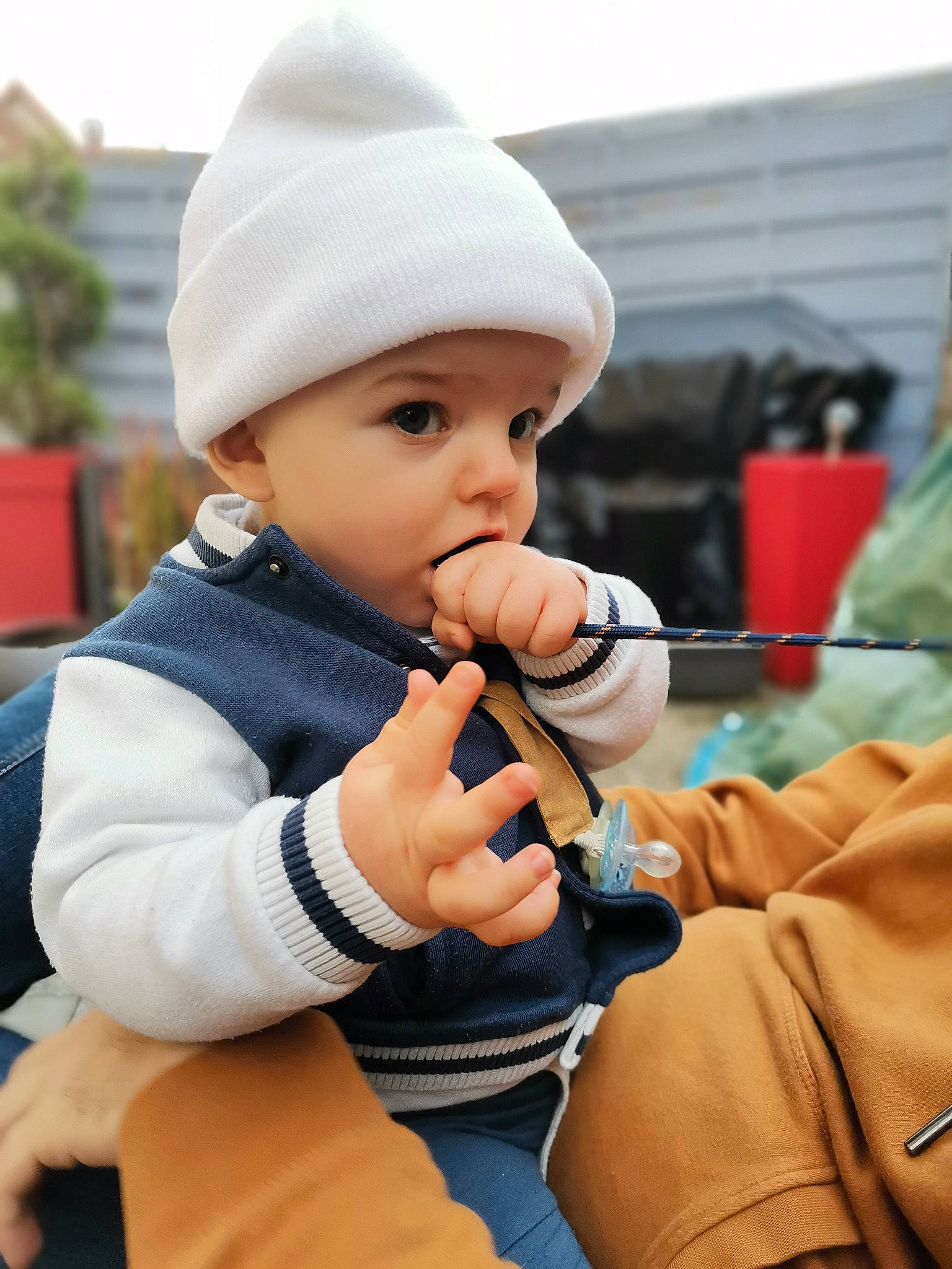 Liam participe au concours pour gagner de l'argent avec cette photo : audio_equipment, baby, baby_toddler_clothing, beanie, cap, child, fashion_accessory, happy, headwear, knit_cap, mobile_phone, nail, person, portrait_photography, sitting, street_fashion, thumb, toddler, tree, vacation