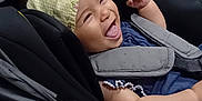 Inaya participe au concours pour gagner de l'argent avec cette photo : baby, baby_arm, baby_face, black_stroller, blue_clothing, child, child_seat, cute, happy, hat, indoors, infant, person, playful, portrait, seatbelt, smiling, stroller, tongue_out, yellow_hat