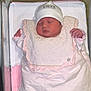 Djenna participe au concours pour gagner de l'argent avec cette photo : newborn, baby, sleeping, hat, blanket, hospital_bassinet, pink, white, clothing, infant, cute, peaceful, face, person, bed, soft, wrapped, child, indoors, resting