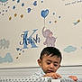 baby_room, balloon, blanket, boy, child, clouds, curious, earring, elephant, face, furniture, head, indoor, name, nursery, painting, soft_texture, stars, toddler, wall_decoration