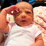 Laynee joined the competition — help win amazing prizes! baby, infant, white_clothing, blanket, hand, face, skin, lying_down, person, cute, newborn, expression, indoors, soft_texture, patterned_blanket, small_hand, sleepy, portrait, baby_garment, closeup