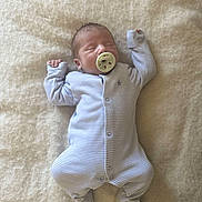 Eddy is registered to the contest to win money with this photo: newborn, baby, sleeping, pacifier, onesie, striped_clothing, infant, soft_blanket, cozy, resting, peaceful, cute, small_hands, footed_pajamas, indoors, child, portrait, sleepwear, relaxed, lying_down