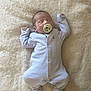 newborn, baby, sleeping, pacifier, onesie, striped_clothing, infant, soft_blanket, cozy, resting, peaceful, cute, small_hands, footed_pajamas, indoors, child, portrait, sleepwear, relaxed, lying_down