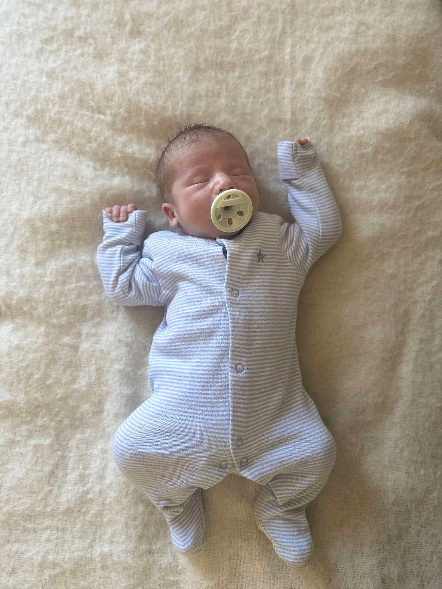 Eddy is registered to the contest to win money with this photo: newborn, baby, sleeping, pacifier, onesie, striped_clothing, infant, soft_blanket, cozy, resting, peaceful, cute, small_hands, footed_pajamas, indoors, child, portrait, sleepwear, relaxed, lying_down