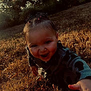 Delilah is registered to the contest to win money with this photo: child, toddler, smiling, happy, outdoor, grass, sunset, nature, baby, face, hand, playing, curly_hair, clothing, field, sunlight, cute, expression, joy, daylight
