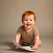 Ivy is registered to the contest to win money with this photo: baby, red_hair, crawling, paper, smiling, child, one_person, indoor, neutral_background, cute, happy, infant, toddler, short_sleeve, studio_lighting, portrait, young_child, playful, skin, eyes