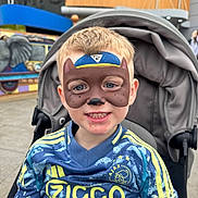 Jace joined the competition — help win amazing prizes! child, face_paint, smiling, stroller, boy, short_hair, blue_jersey, sportswear, outdoor, amusement_park, background, elephant_mural, happy, portrait, casual_clothing, daylight, public_place, young, face, person