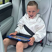Jaxon joined the competition — help win amazing prizes! child, boy, car_seat, seatbelt, tablet, freckles, white_hoodie, shorts, sneakers, car_interior, road_trip, window, greenery, happy, smiling, technology, modern, seat, safety, casual_clothing