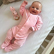 Kendal joined the competition — help win amazing prizes! baby, infant, crib, pink_onesie, toy, knitted_bunny, smiling, happy, lying_down, white_bedding, nursery, wooden_crib, child, cute, soft_light, peaceful, indoors, portrait, newborn, sleepwear