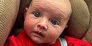 Kendal is registered to the contest to win money with this photo: baby, infant, car_seat, red_clothing, blue_eyes, face, child, seatbelt, closeup, portrait, cute, young_child, comfort, soft_texture, indoor, expression, looking_at_camera, head, skin, clothing