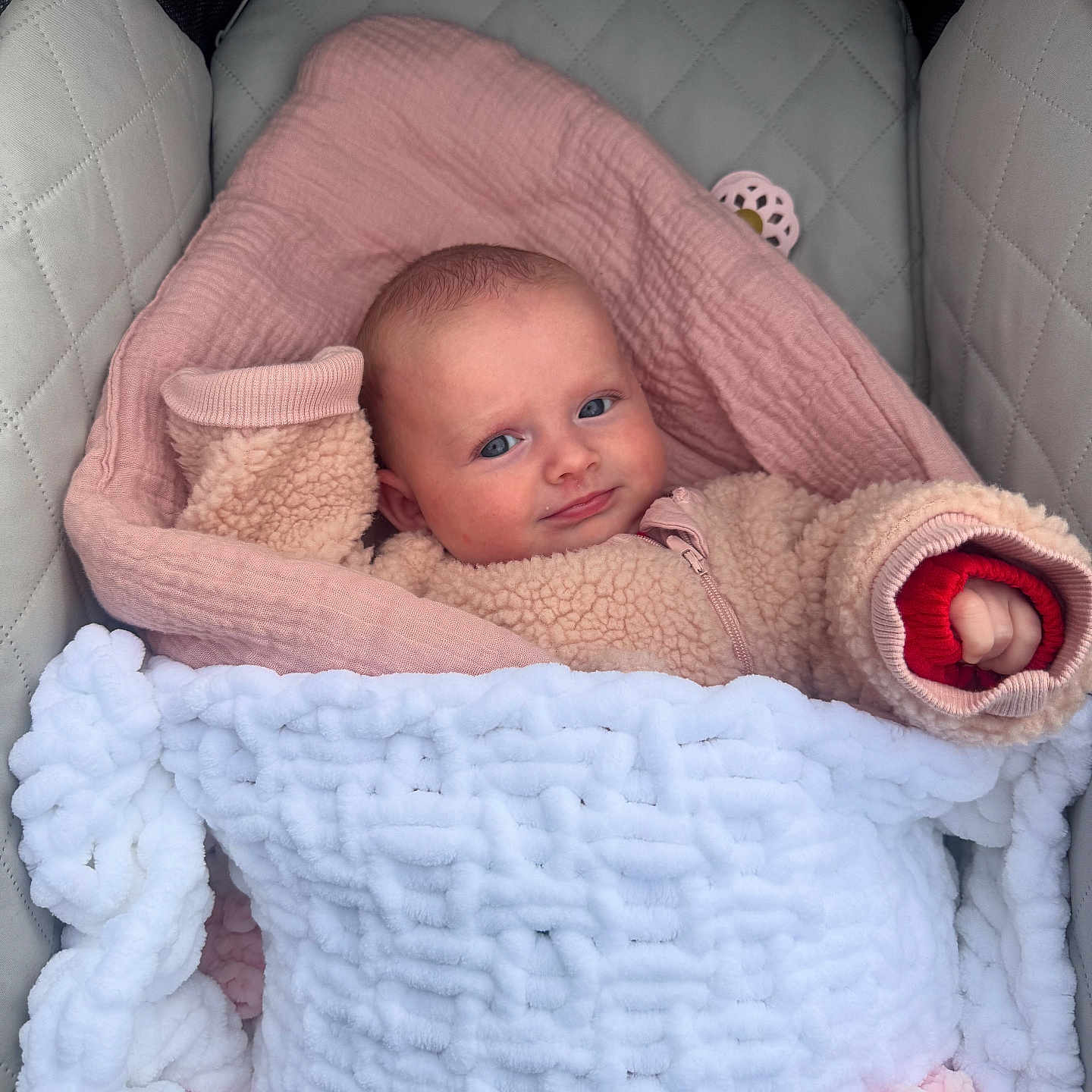 Kendal is registered to the contest to win money with this photo: baby, blanket, blue_eyes, carrier, cushion, cute, face, fleece, infant, pink, portrait, resting, smile, snug, soft, toddler, warm_clothing, wearing, wrapped, young_child