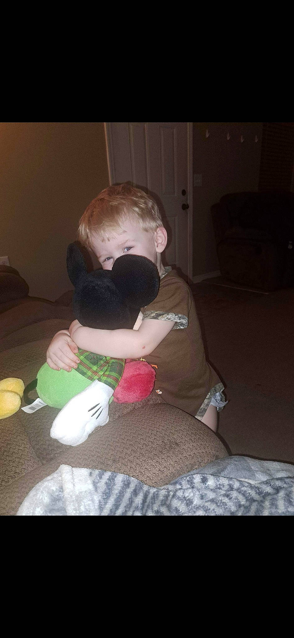 Hunter is registered to the contest to win money with this photo: baby, child, comfort, couch, eyewear, flooring, fur, hair, happy, human_leg, lap, leg, linens, person, plush, room, sitting, stuffed_toy, thigh, toddler