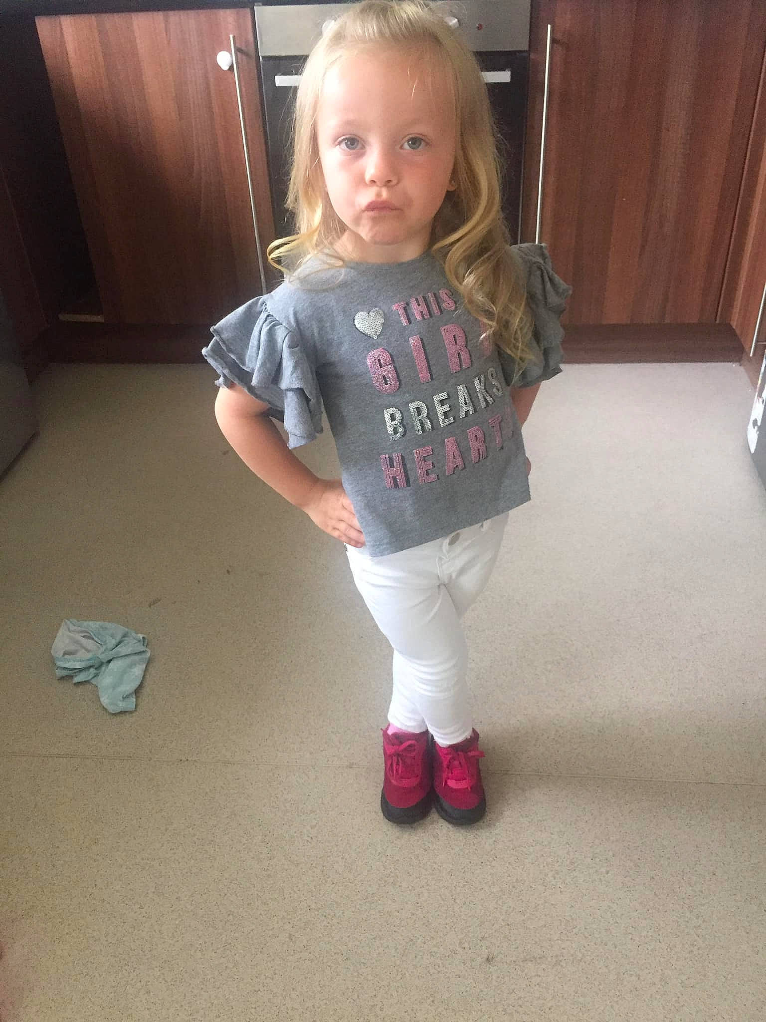 Mia-rose is registered to the contest to win money with this photo: arm, blond, child, floor, flooring, footwear, fun, jeans, joint, leg, outerwear, person, shoe, shoulder, skin, sleeve, smile, standing, t_shirt, textile