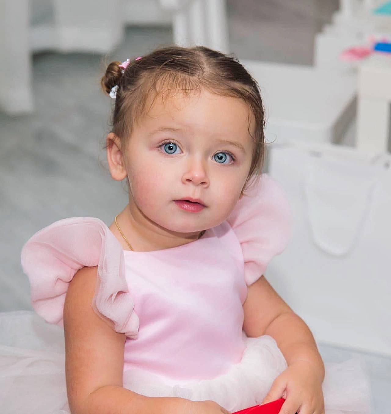 Chelsea participe au concours pour gagner de l'argent avec cette photo : baby, baby_toddler_clothing, beauty, brown_hair, cheek, child, child_model, daughter, ear, eye, face, head, iris, lip, person, pink, sitting, skin, toddler