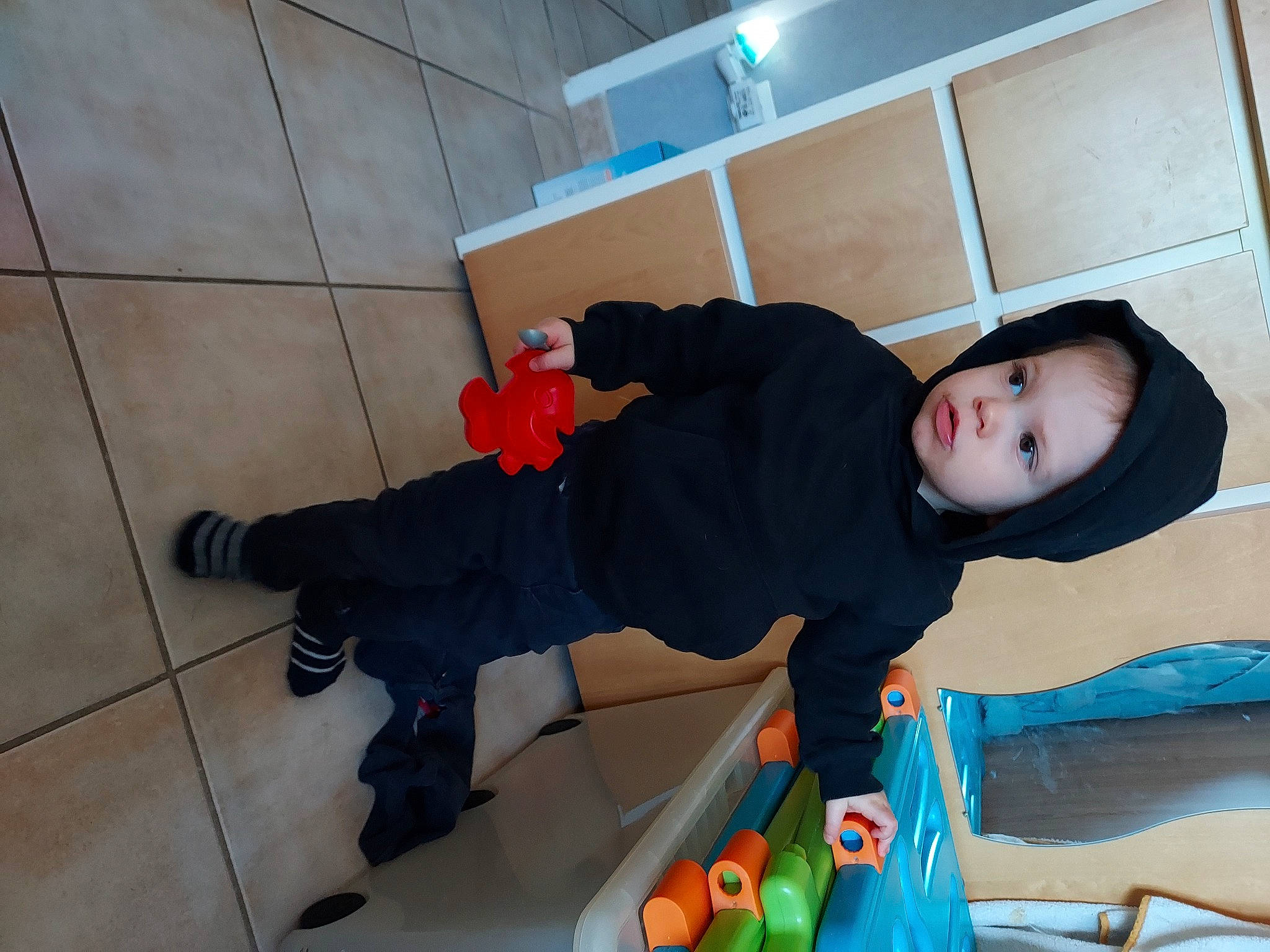 Léo participe au concours pour gagner de l'argent avec cette photo : baby, baby_toddler_clothing, child, cleanliness, comfort, flooring, foot, fun, hardwood, headwear, human_leg, knee, leg, outdoor_shoe, person, play, room, sitting, sock, sweatpant