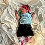 newborn, baby, sleeping, pacifier, headband, pink_bow, blue_shirt, black_shorts, white_sheet, sock, infant, clothing, lying_down, peaceful, cute, indoors, soft_texture, fabric, small_hands, small_feet
