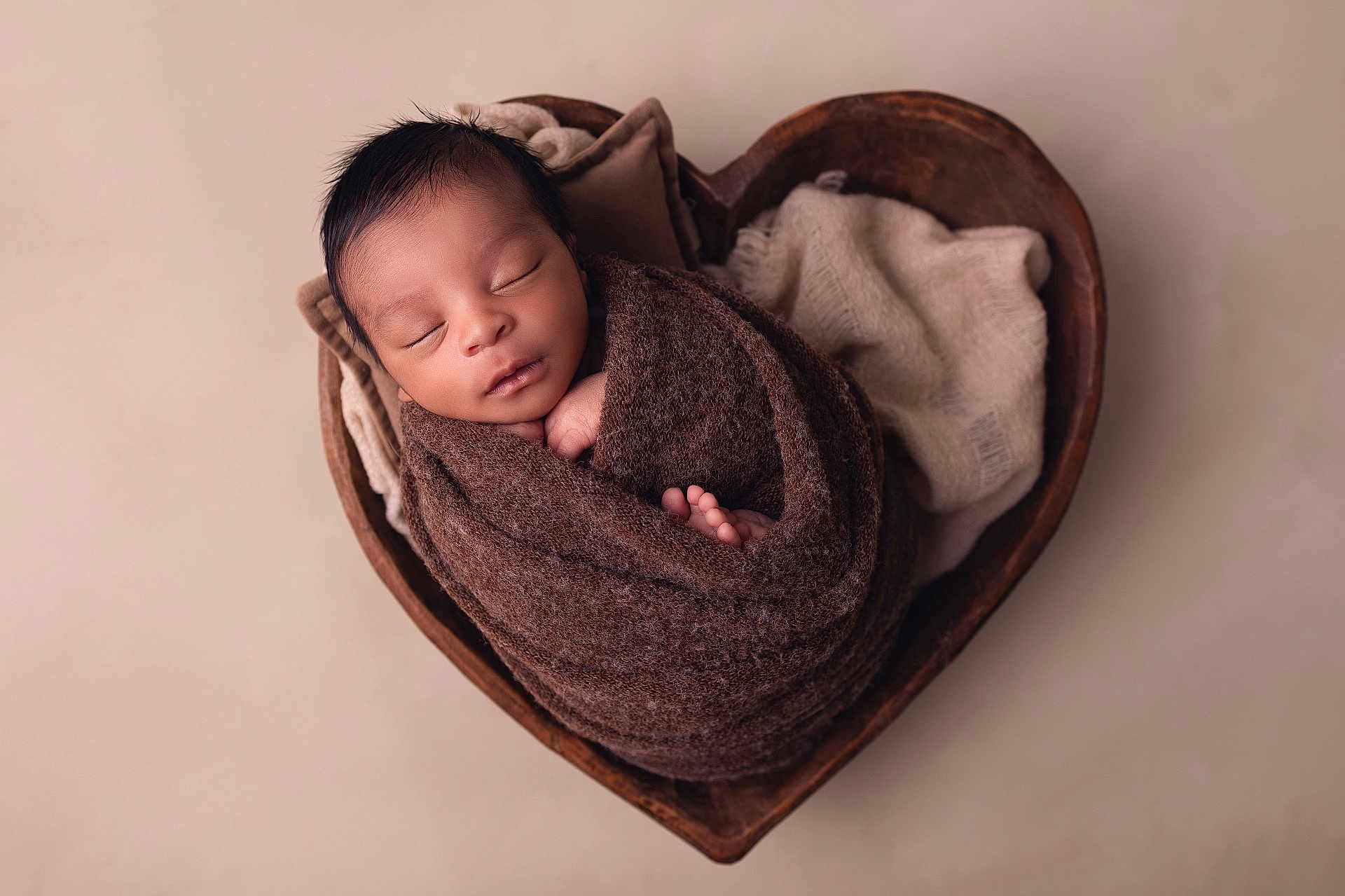Jaïyden participe au concours pour gagner de l'argent avec cette photo : newborn, baby, sleeping, wrapped, blanket, brown, heart_shaped_bowl, wooden, soft_fabric, cozy, peaceful, portrait, infant, cute, toddler, child, skin, head, closed_eyes, indoor
