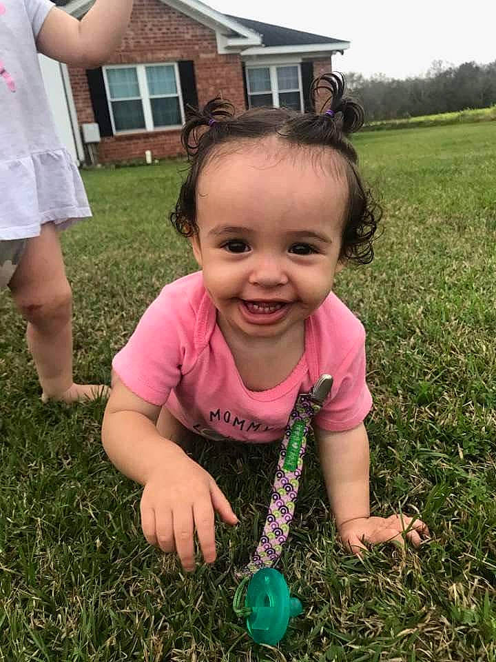 Clementine is registered to the contest to win money with this photo: baby_toddler_clothing, ball, child, fun, grass, grassland, happy, house, joy, lawn, people_in_nature, person, pink, plant, shorts, sky, smile, soil, t_shirt, thumb