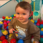 Giovanni participe au concours pour gagner de l'argent avec cette photo : child, baby, infant, ball_pit, colorful_balls, mickey_sweatshirt, smile, big_eyes, cheeks, indoor, toy, plush, playmat, sitting, portrait, hair, happy, clothing, hands, skin