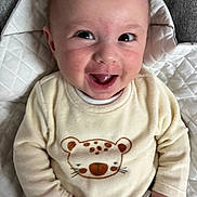 Giovanni participe au concours pour gagner de l'argent avec cette photo : apparel, baby, blanket, cheerful, child, clothing, cozy, cute, cute_animal_print, cute_expression, face, hand, happy, indoors, infant, person, portrait, sitting, smiling, young