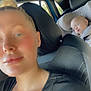 adult, baby, car, car_seat, child, female, person, seat, seatbelt, sleeping, interior, window, hair_bun, casual_clothing, portrait, relaxation, daylight, travel, transportation, rest
