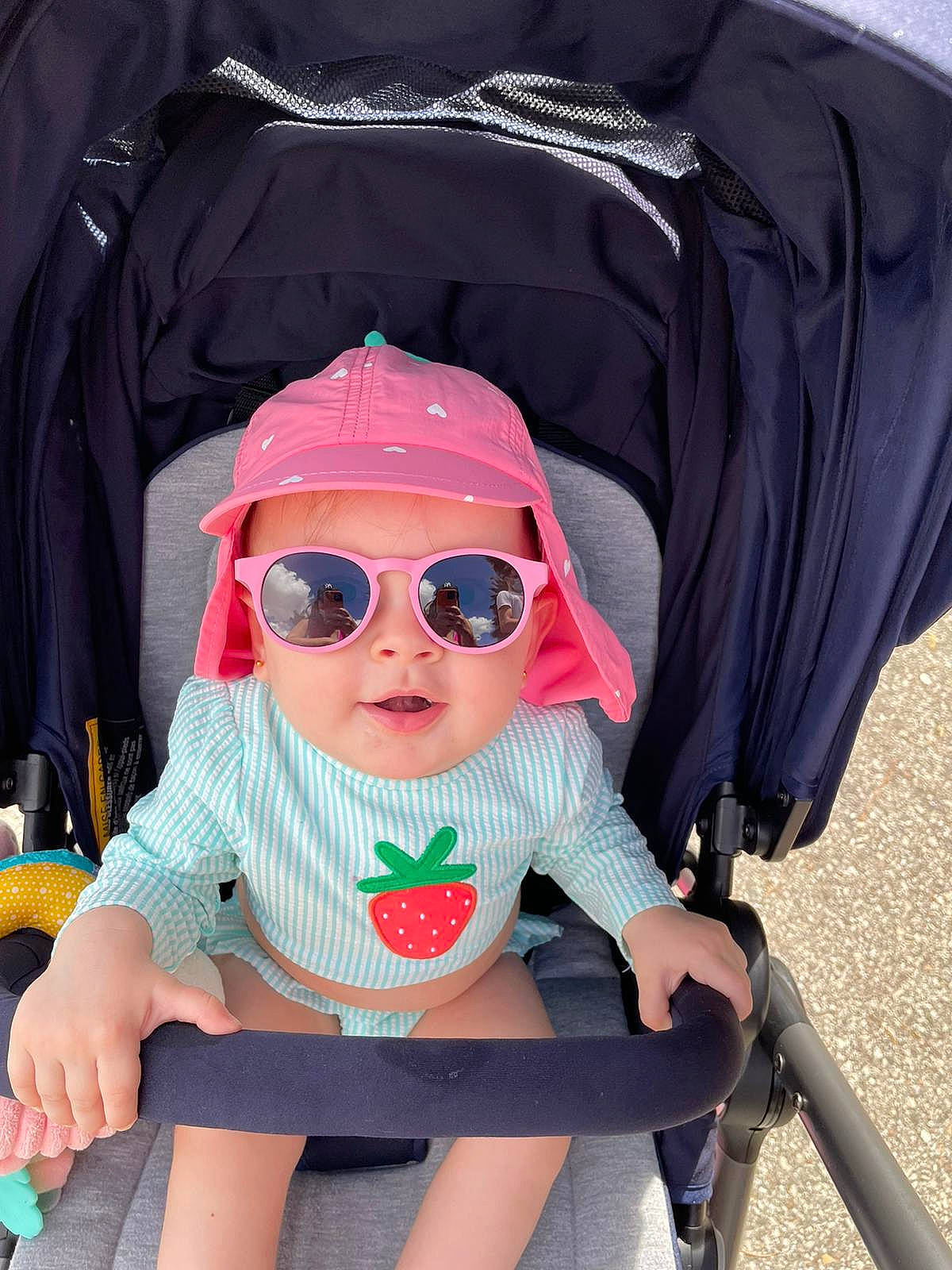 Laura is registered to the contest to win money with this photo: baby, baby_carriage, baby_products, baby_toddler_clothing, cap, child, comfort, cool, eyewear, glasses, goggles, headwear, person, personal_protective_equipment, pink, product, sleeve, sunglasses, thigh, toddler