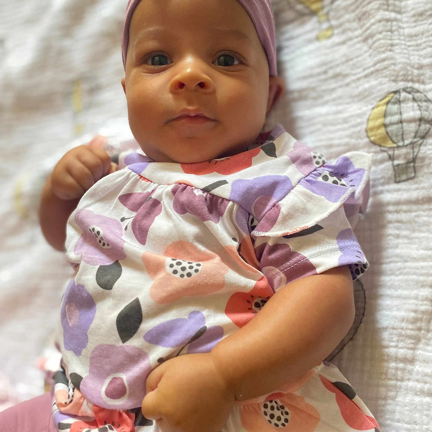 Hanaé a rejoint le concours — aidez-le/la à gagner de superbes lots ! adorable, baby, blanket, bow, child, closeup, clothing, colorful, cute, dress, floral_pattern, headband, hot_air_balloon, indoors, infant, lying_down, person, portrait, soft_texture, young_child