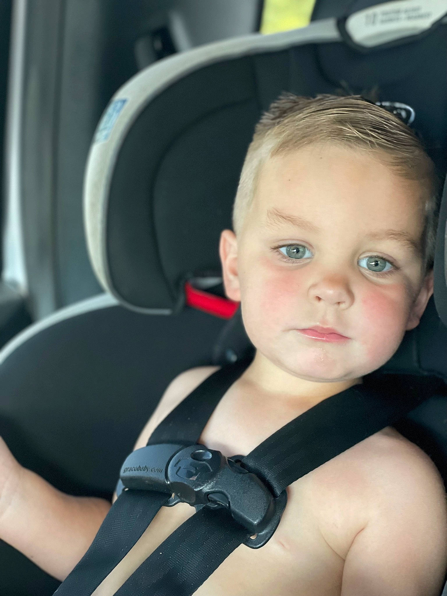 Clarence is registered to the contest to win money with this photo: audio_equipment, auto_part, automotive_design, baby, baby_products, black_hair, car_seat, chest, child, comfort, eyebrow, eyelash, flash_photography, head_restraint, person, seat_belt, sitting, steering_part, steering_wheel, toddler